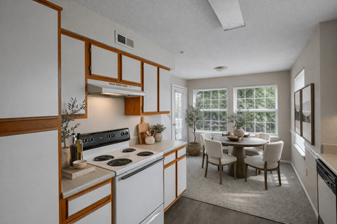 A kitchen with a dining table and chairs.