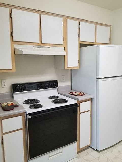 a kitchen with white appliances and white cabinets