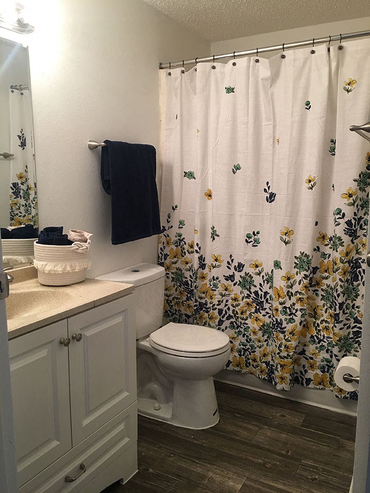 a bathroom with a toilet and a shower curtain