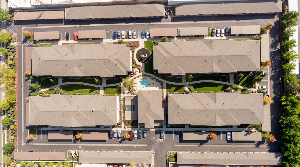 an aerial view of a neighborhood of houses with cars on the street