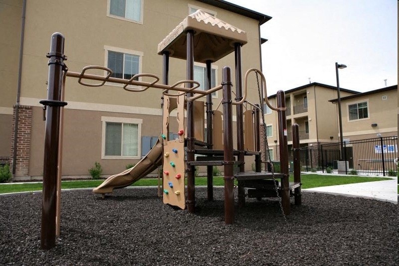 a playground with a slide in front of a building