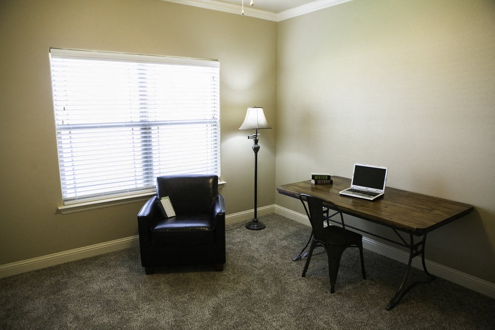 a small office with a chair and a desk with a laptop