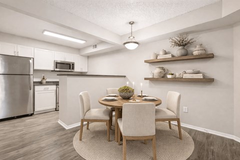 A modern kitchen with a dining table set for two.