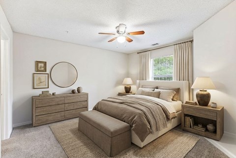 A bedroom with a bed, nightstand, and a dresser.