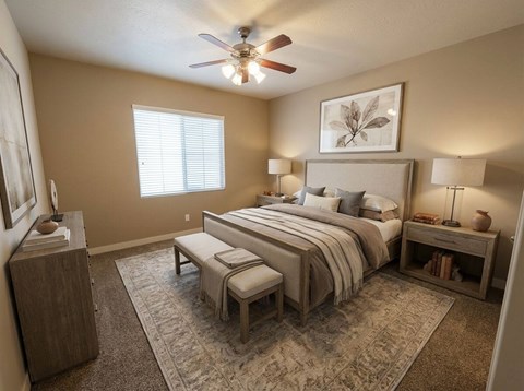 A bedroom with a large bed, a ceiling fan, and a rug on the floor.