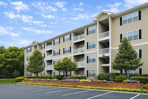A large apartment building with a parking lot in front.