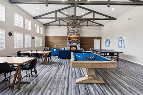 A room with a pool table and a fireplace.