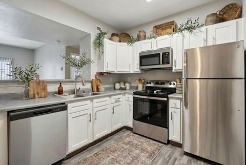 A modern kitchen with stainless steel appliances and white cabinets.