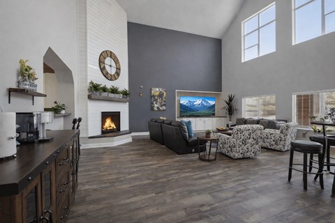 A living room with a fireplace and a painting of a mountain scene on the wall.