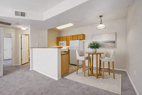 A kitchen with a dining table and chairs.