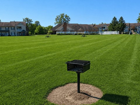 Community grilling area with picnic tables at Arbors at Georgetown Apartments, Lansing, MI