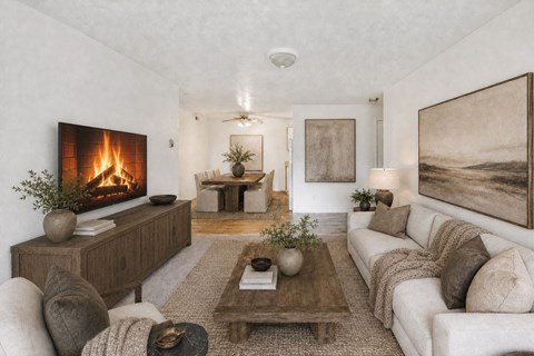 A modern living room with a fireplace and a painting on the wall.
