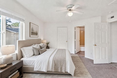 A bedroom with a large bed and a ceiling fan.