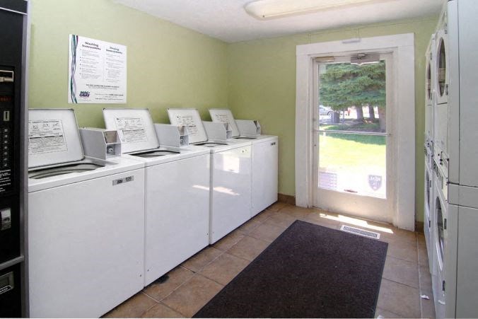 a laundry room with a row of washing machines