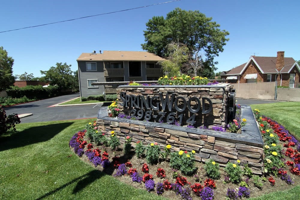 a yard with flowers and a sign in front of a house