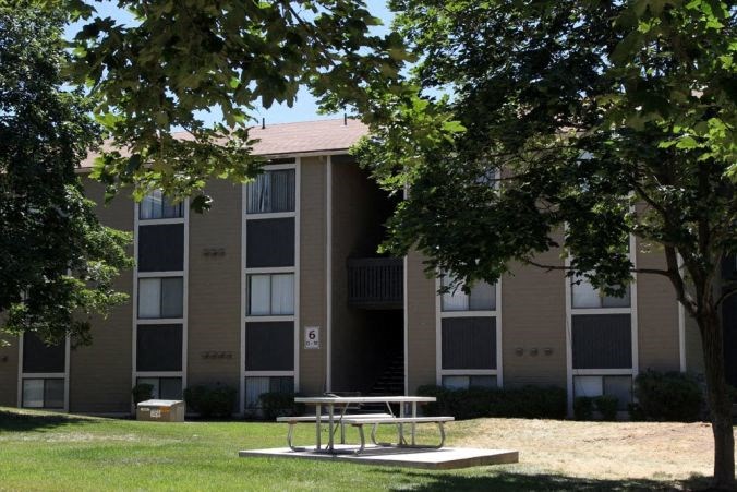 an outdoor picnic table in front of an apartment building