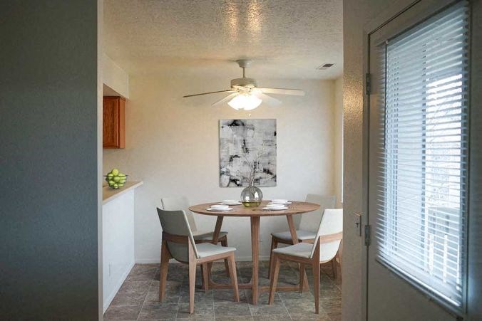 a dining room with a table and chairs and a ceiling fan