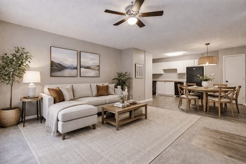 A living room with a white sofa, a wooden coffee table, and a ceiling fan.