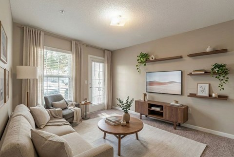 A living room with a large couch, a coffee table, and a painting on the wall.