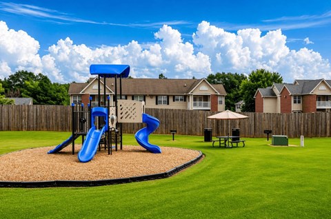 A playground with a blue slide and a brown and tan slide.