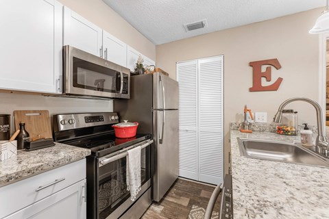 A kitchen with a black stove top oven and a black microwave above it.