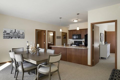 Open concept dining area and kitchen with island at The Estates at Arbor Oaks Apartments, Andover