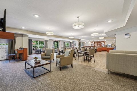 A spacious living room with a variety of furniture including a sofa, armchairs, and a coffee table.