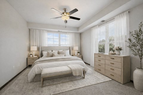 A bedroom with a large bed, a ceiling fan, and a window with blinds.