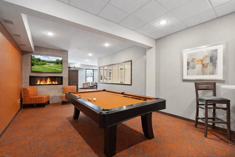 A room with a pool table and a fireplace.