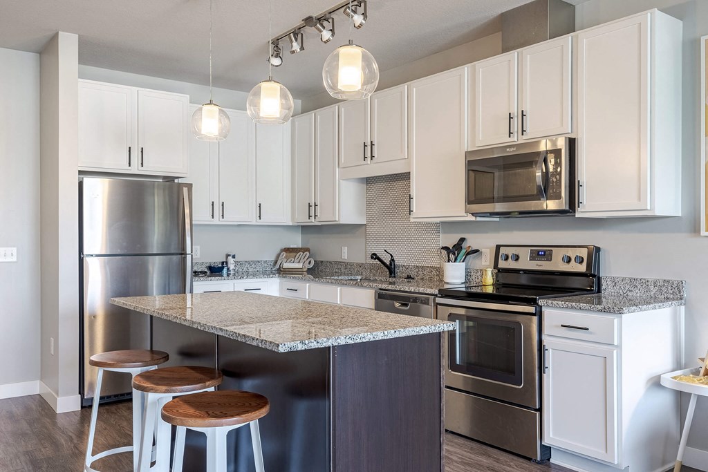 A kitchen with white cabinets and a granite countertop. at Hello Apartments, Minneapolis