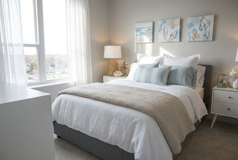 A bedroom with a large bed and two lamps.