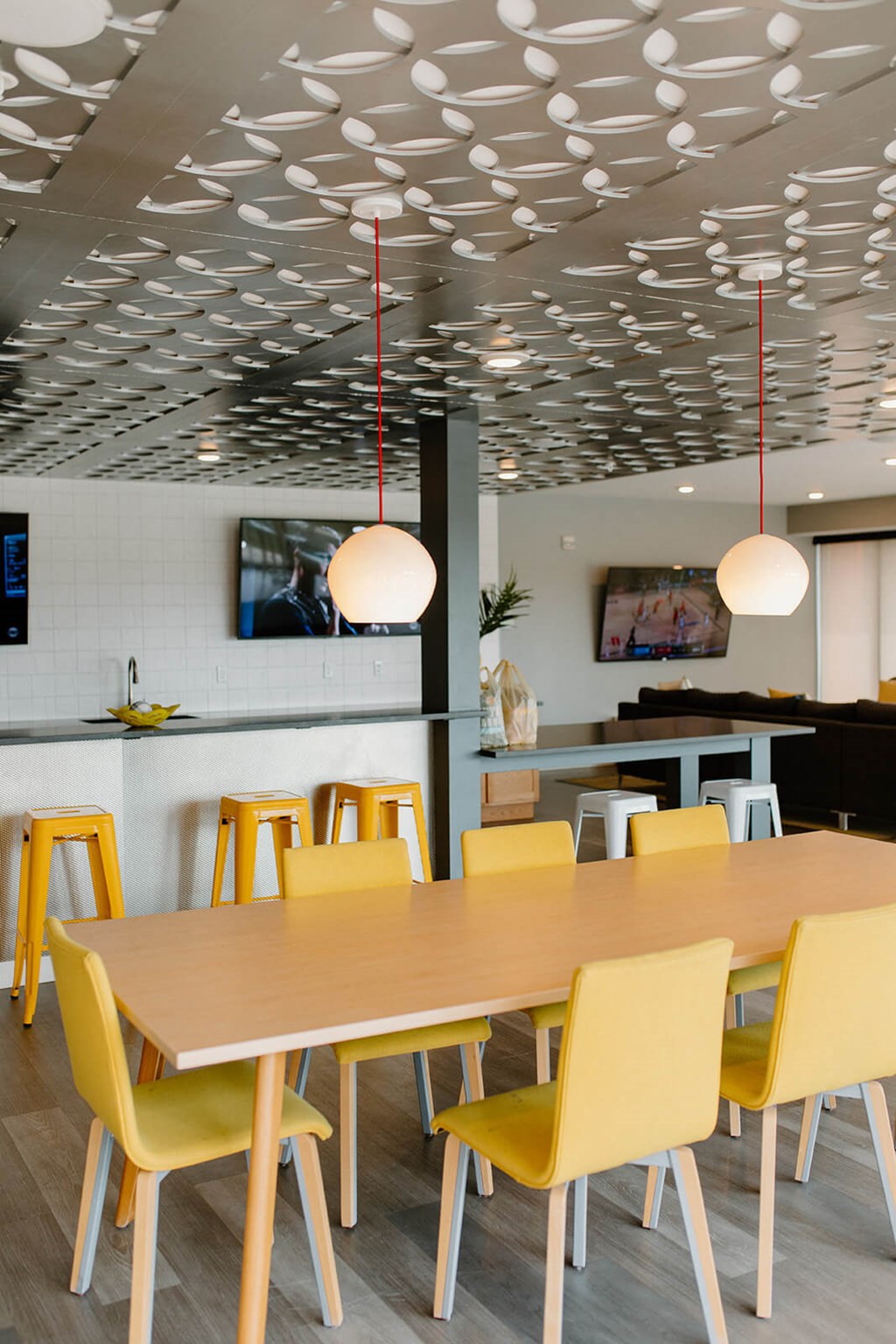 A dining room with a table and yellow chairs. at Hello Apartments, Minneapolis