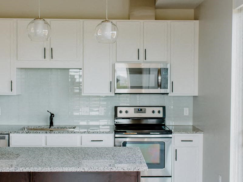 A kitchen with white cabinets and a granite countertop. at Hello Apartments, Minneapolis, 55427