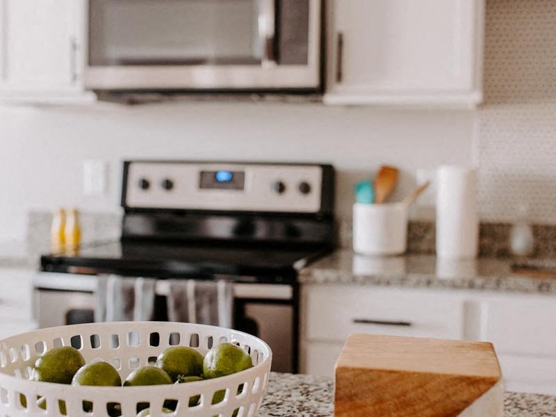 A white bowl with green limes in it sits on a countertop. at Hello Apartments, Minneapolis