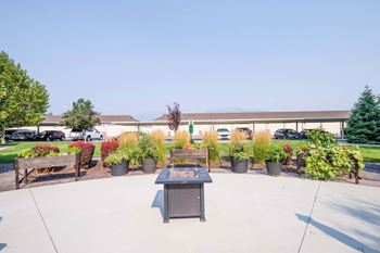 a patio with benches and a table in front of a building