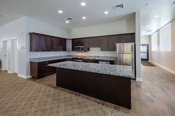 a large kitchen with granite counter tops and stainless steel appliances