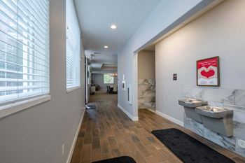 a bathroom with two sinks and a large window and a long hallway with a toilet