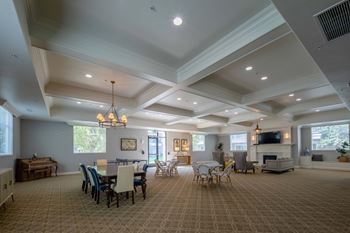 a large living room with a table and chairs and a fireplace
