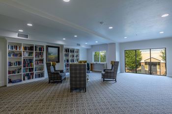 a large living room with a library and a large window