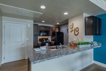 a kitchen with a granite counter top and a black refrigerator The Beckstead, South Jordan, UT, 84095
