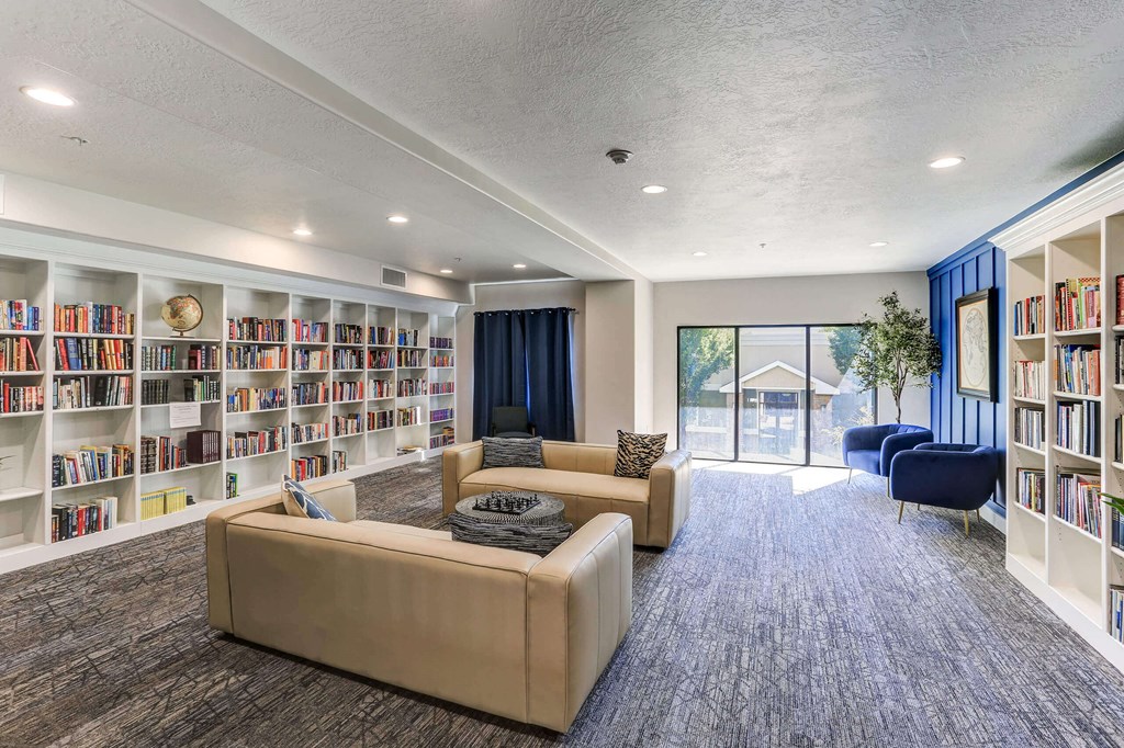 a living room with couches and chairs in front of a large bookshelf at The Beckstead, South Jordan, Utah