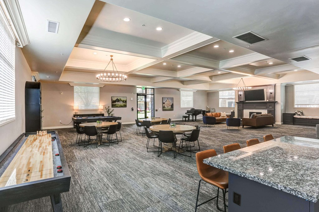 a resident clubhouse with tables and chairs and a foosball table at The Beckstead, South Jordan, UT