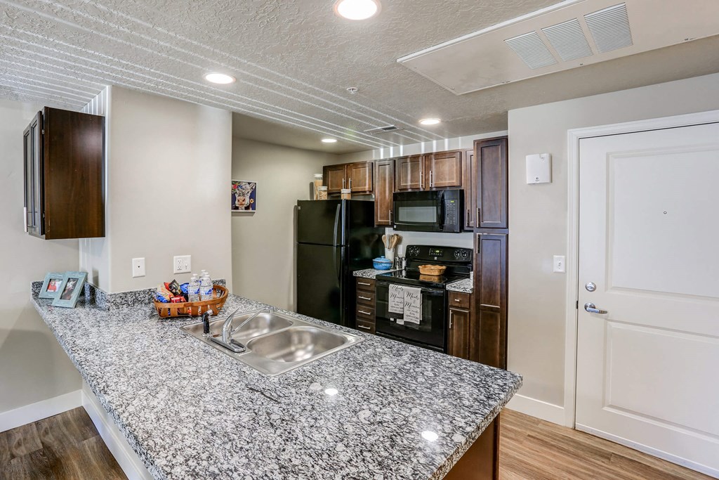 a kitchen with granite countertops and stainless steel appliances at The Beckstead, South Jordan