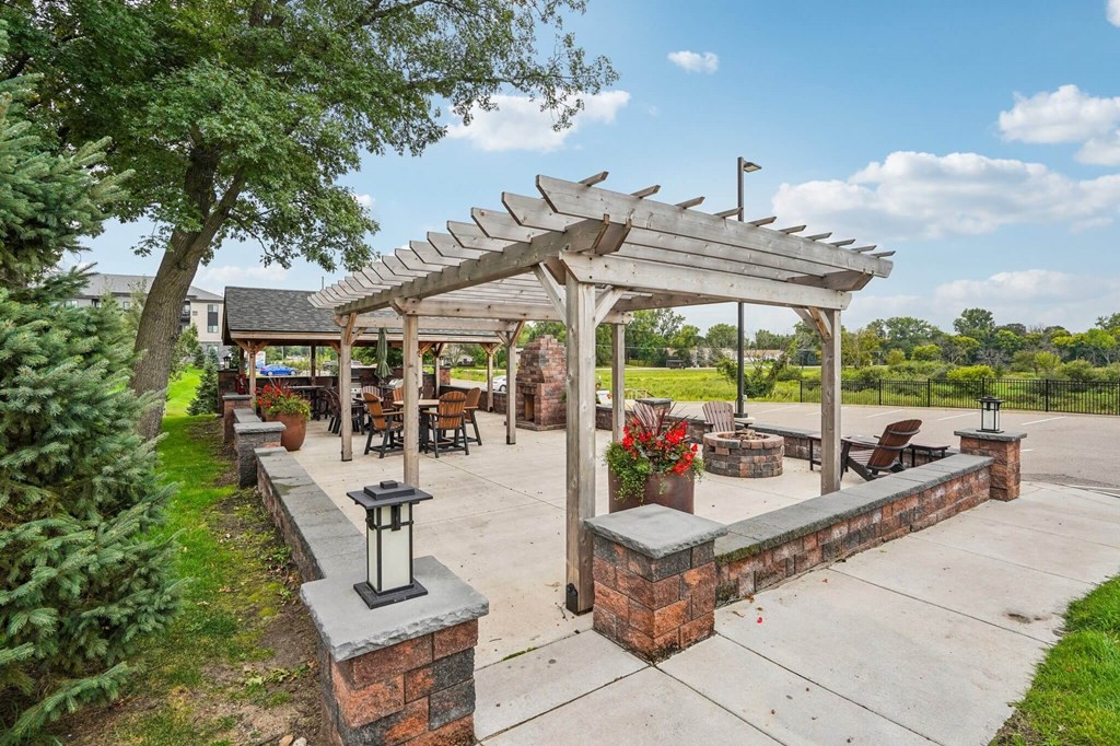 A patio with a pergola and a fire pit. at Aster Meadow, Vadnais Heights, 55127