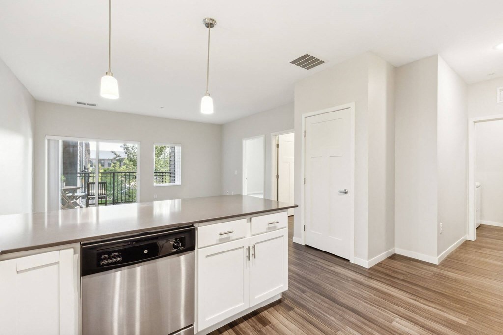 A kitchen with white cabinets and a stainless steel dishwasher. at Aster Meadow, Vadnais Heights, MN