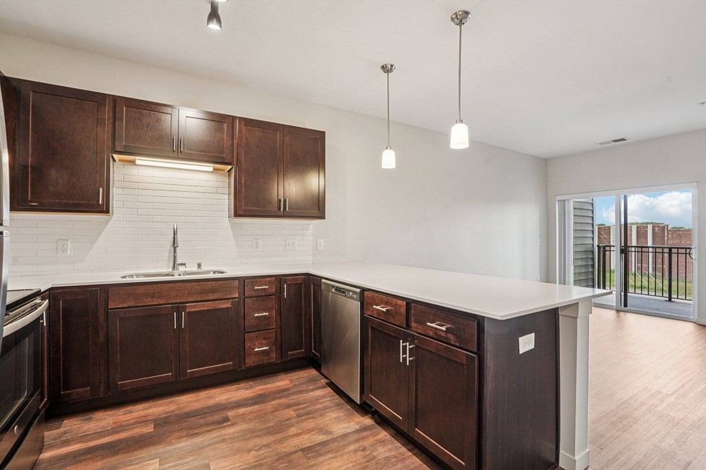 A kitchen with dark wood cabinets and a white countertop. at Aster Meadow, Minnesota, 55127