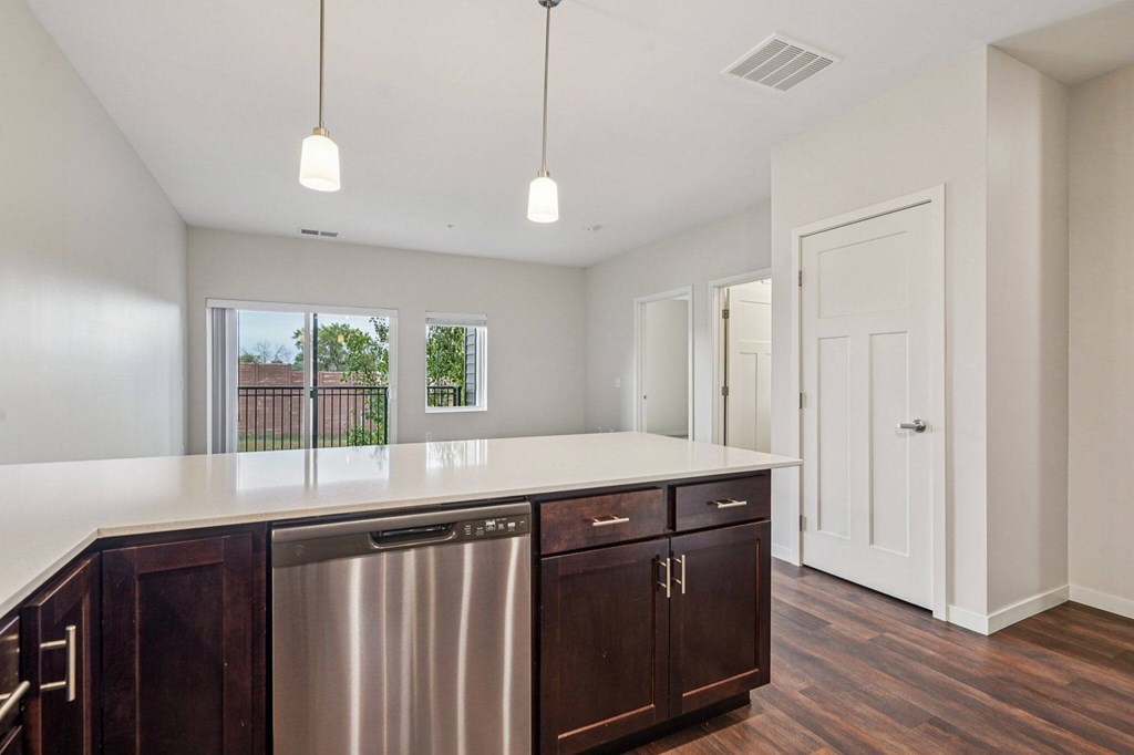 A kitchen with dark wood cabinets and a stainless steel dishwasher. at Aster Meadow, Vadnais Heights, 55127