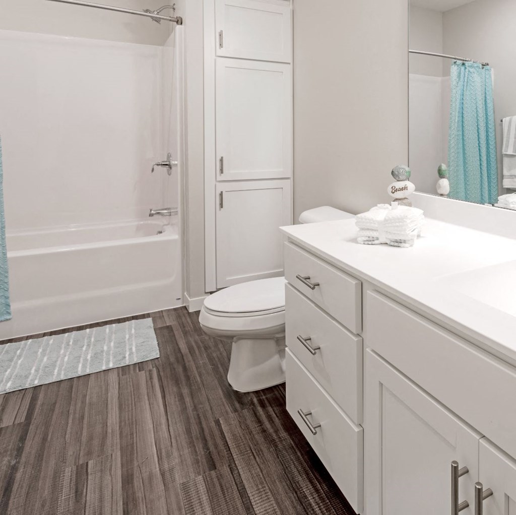 A white bathroom with a toilet, sink, and shower. at Aster Meadow, Minnesota, 55127