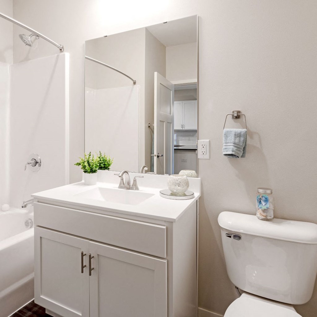 A white bathroom with a toilet, sink, and bathtub. at Aster Meadow, Vadnais Heights, MN