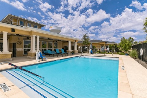 A large swimming pool with a building in the background.